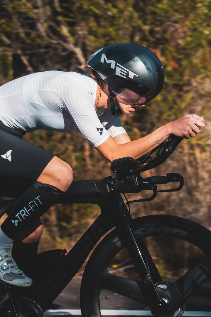 Women wearing TRI-FIT VORTEX tri-suit on a triathlon bike