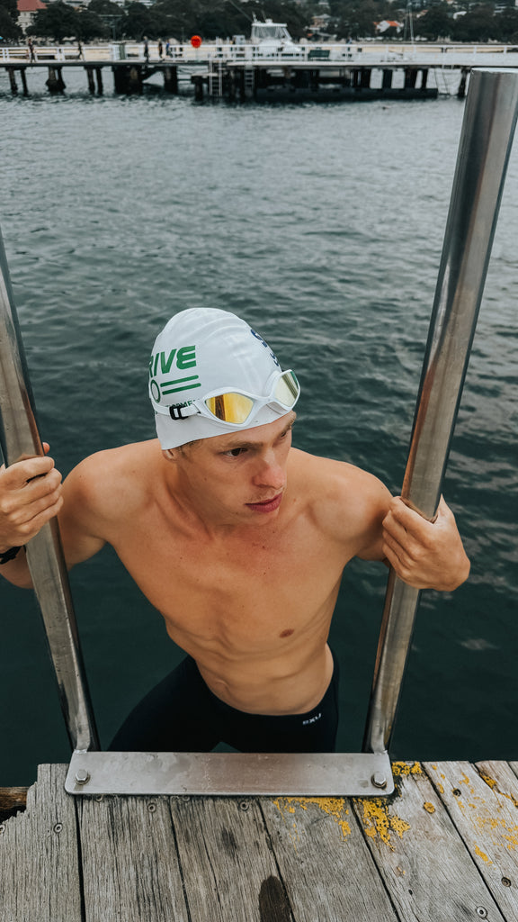 Male swimmer wearing TRI-FIT RAPID-X swim goggles in white