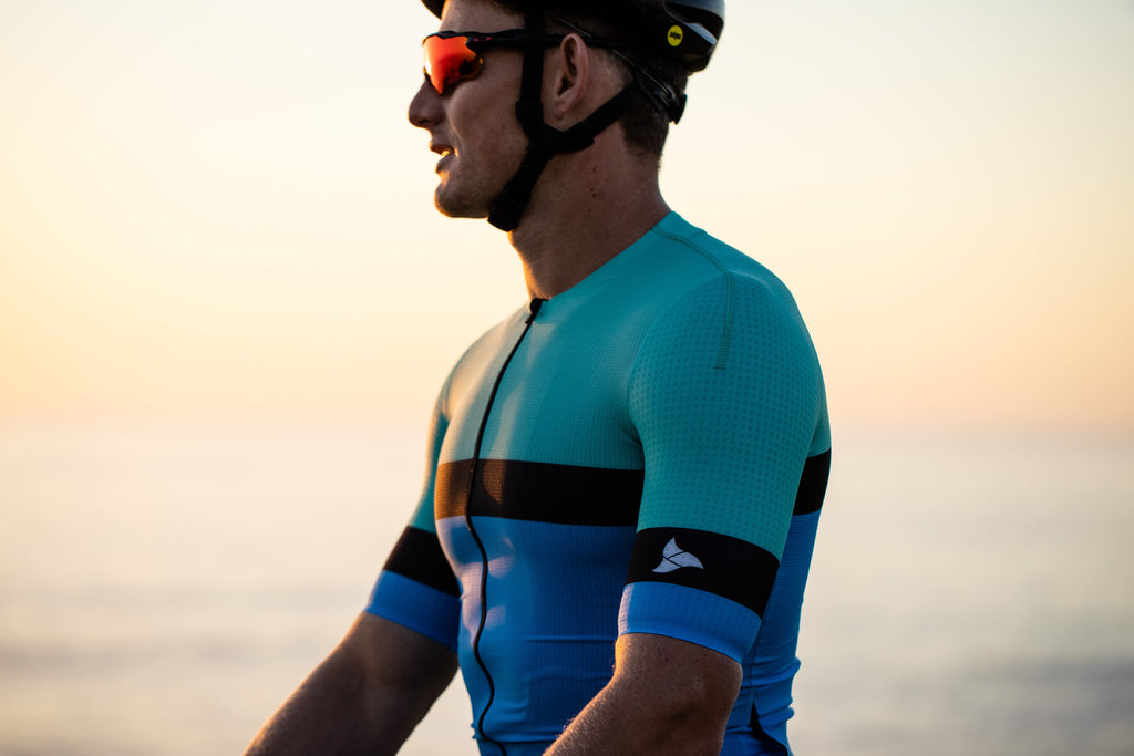 man wearing the SYKL PRO cycling jersey looking out at the sunset