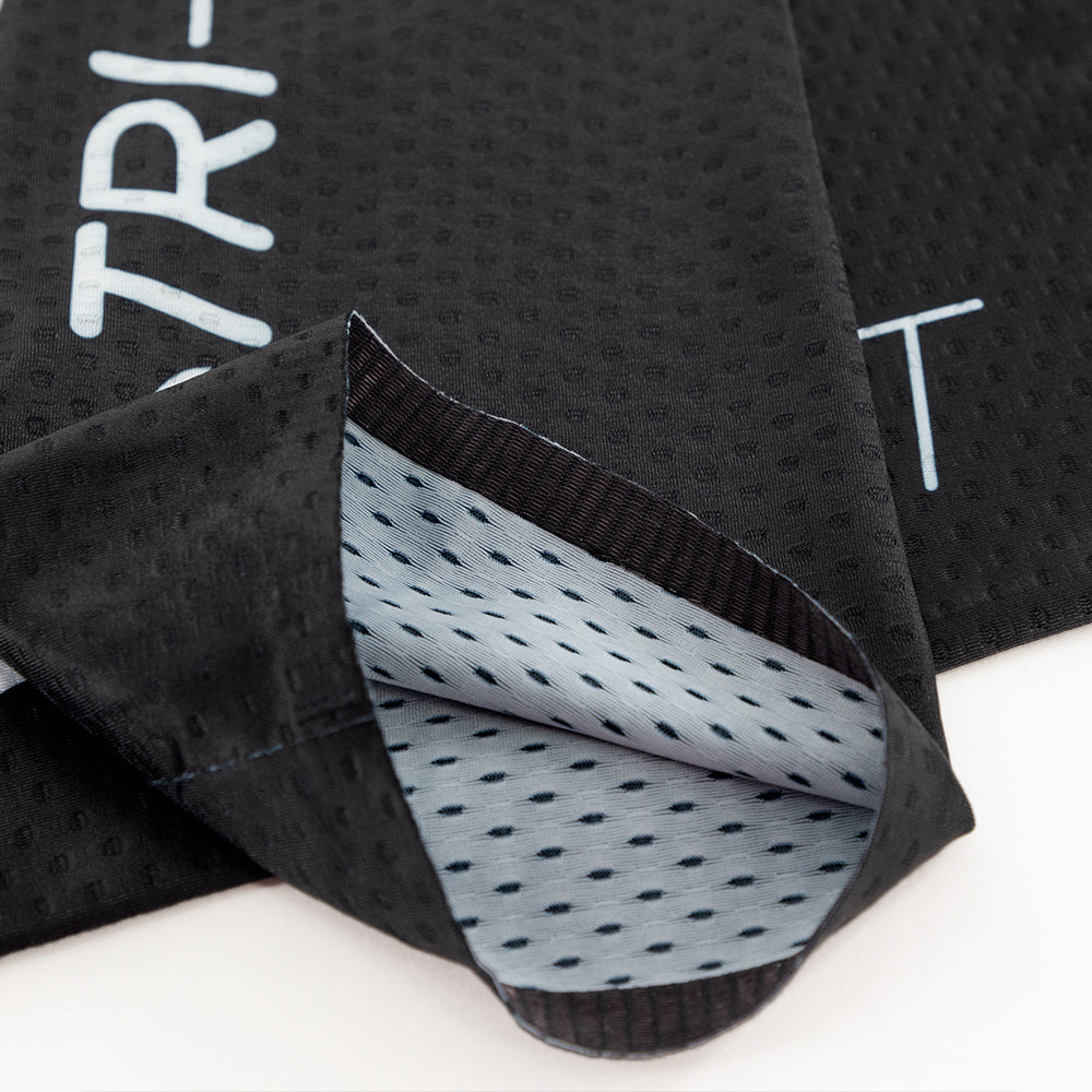Fabric and hem construction detail of black CORE Calf Sleeves showing lightweight, dimpled material.