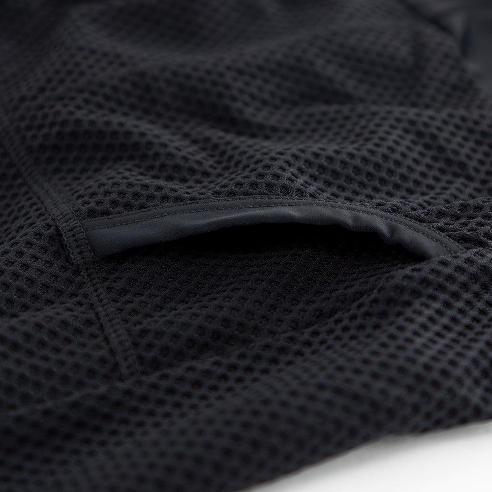 Detail of heat-welded rear pocket entrance on men’s VANGUARD tri-suit in black, showing reinforced mesh finish
