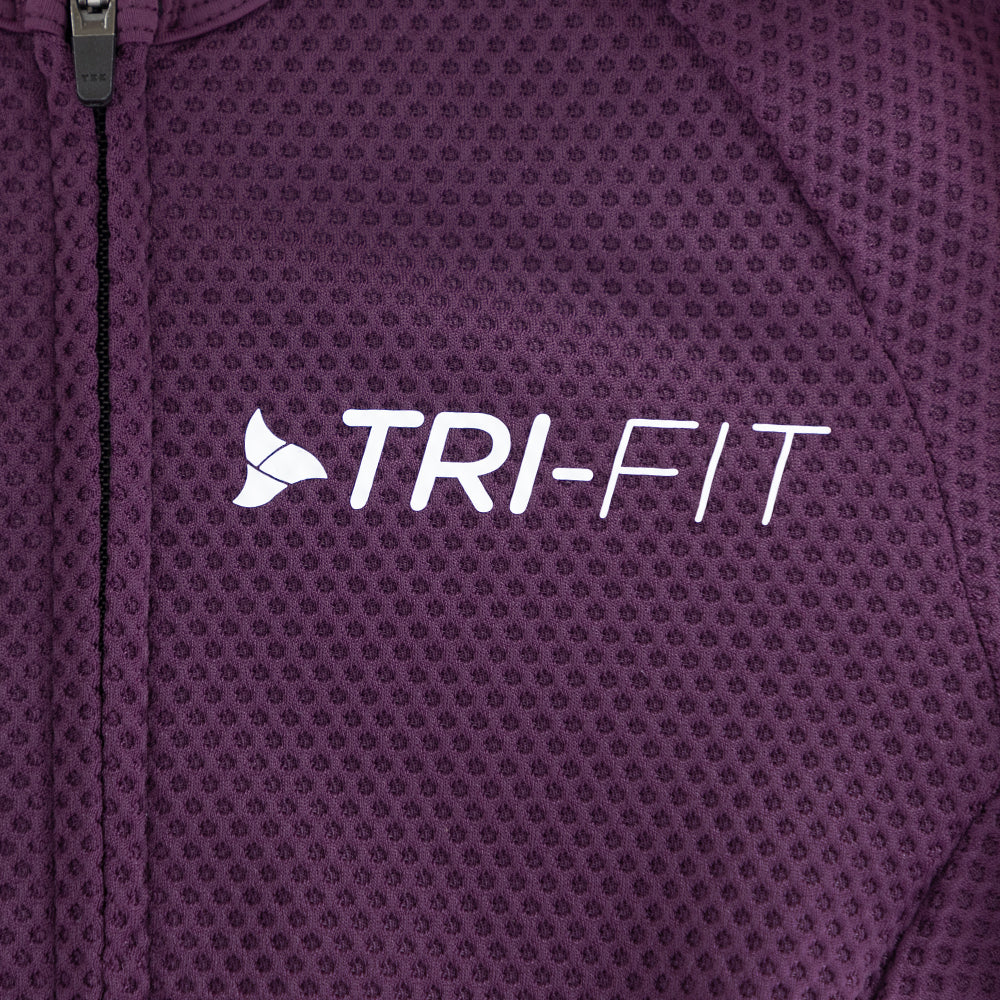 Close-up of TRI-FIT logo printed on the chest of the VANGUARD tri-suit in plum, showing textured breathable fabric